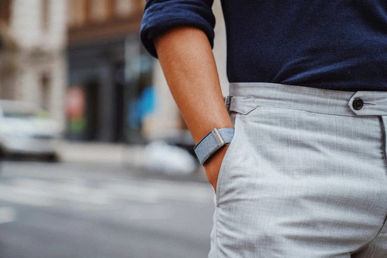 man's grey pants and blue sweater and the shirt that his wrist has been worn