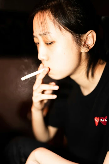 a young woman sitting in a chair smoking a cigarette