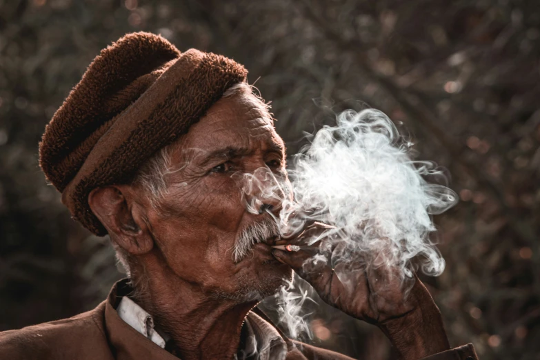 an old man smoking soing with his hand