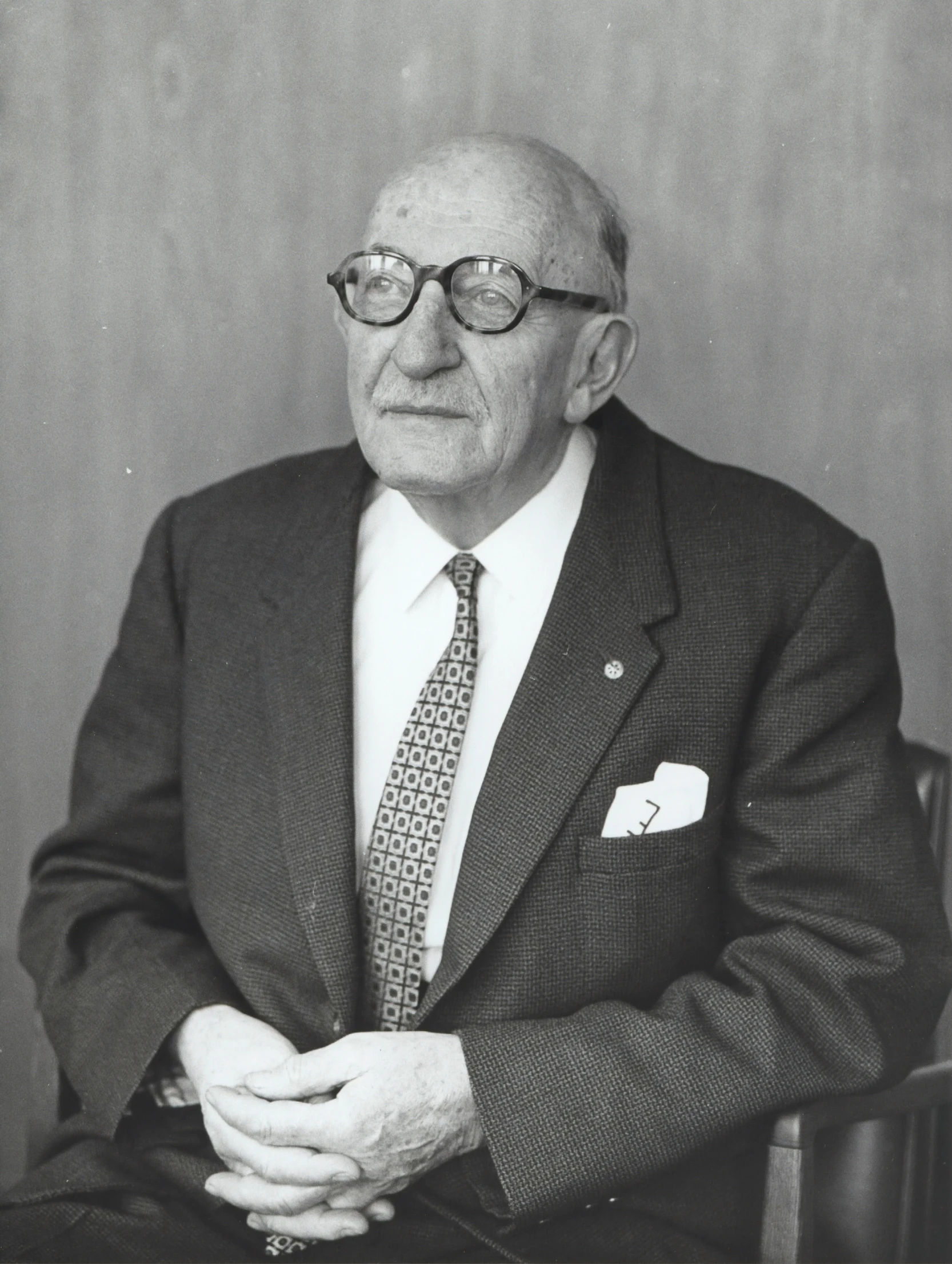 the man is sitting at a desk wearing glasses