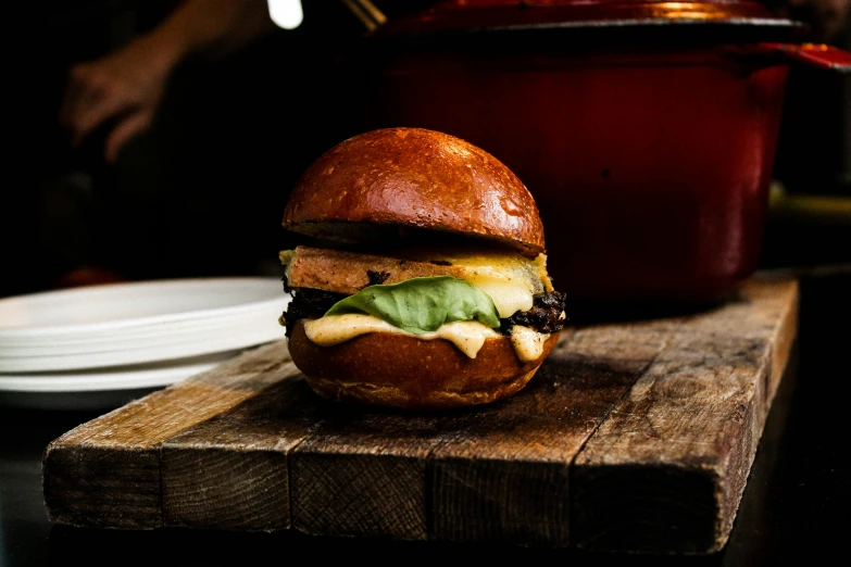 a hamburger on top of a  board with a fork