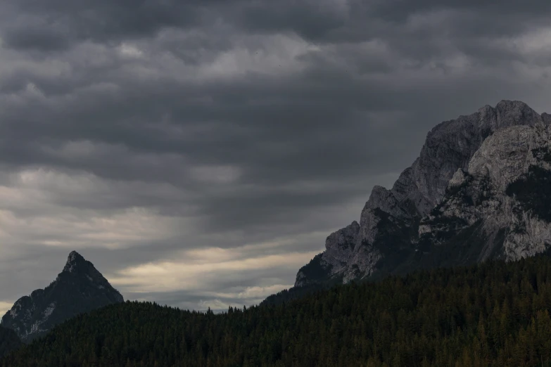 a dark cloud hovers over a mountain