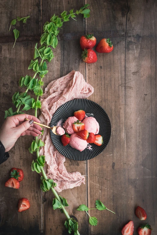 an uncut strawberry is shown on a black plate