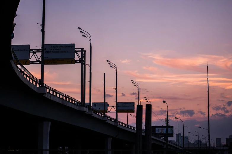 many signs on the street against a twilight sky