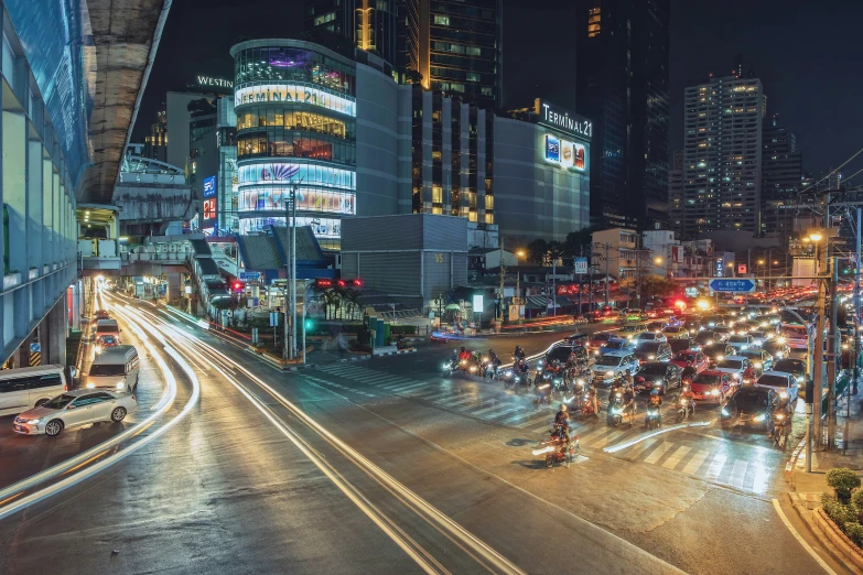 an urban scene at night with cars driving on a street