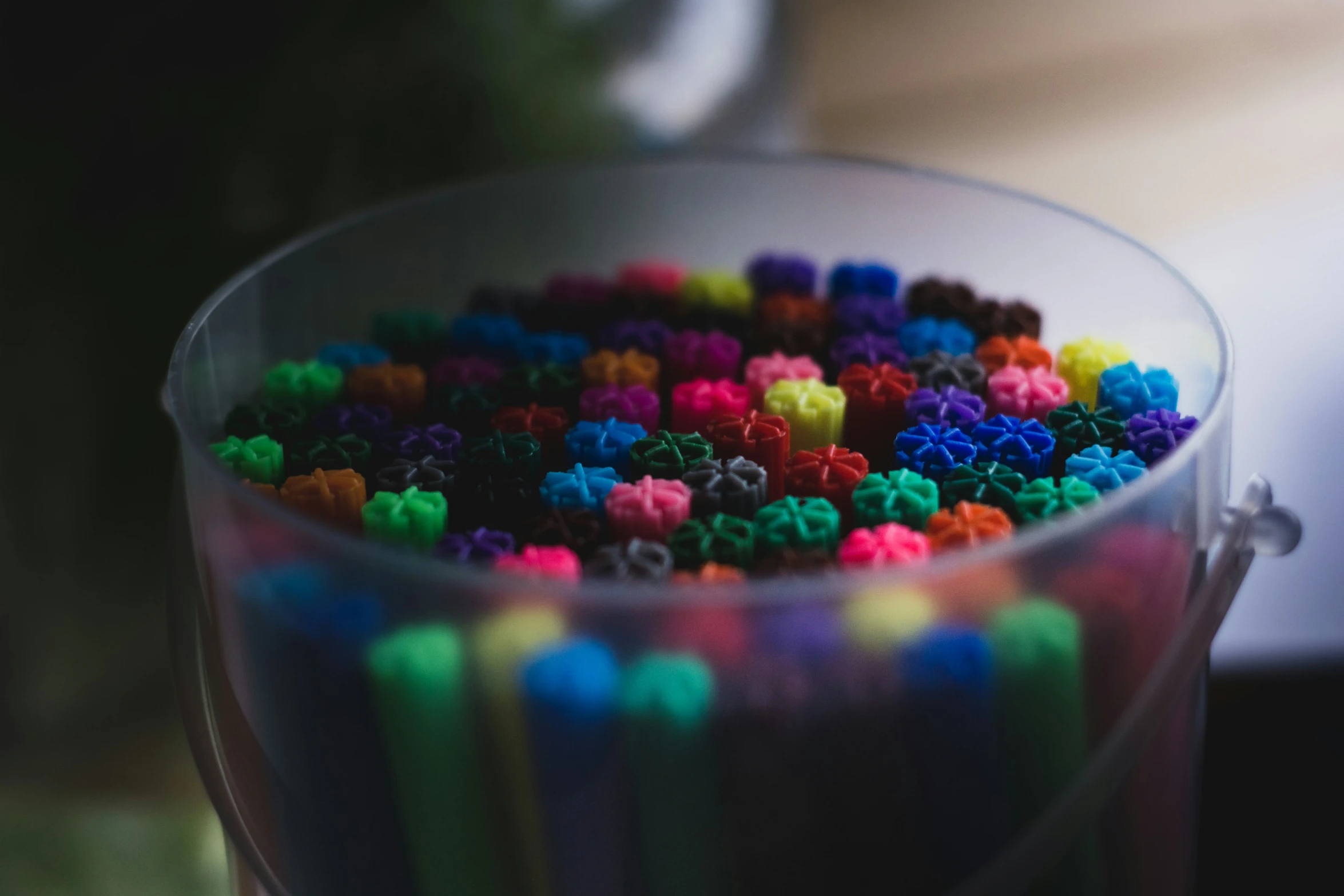 a bucket filled with lots of colorful colored beads