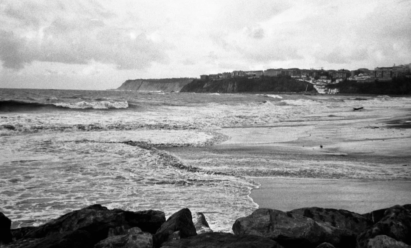 a man walking on the beach next to the water