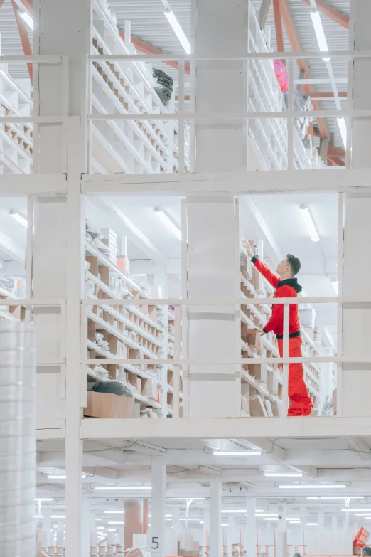 a woman in red jacket in large room with white walls