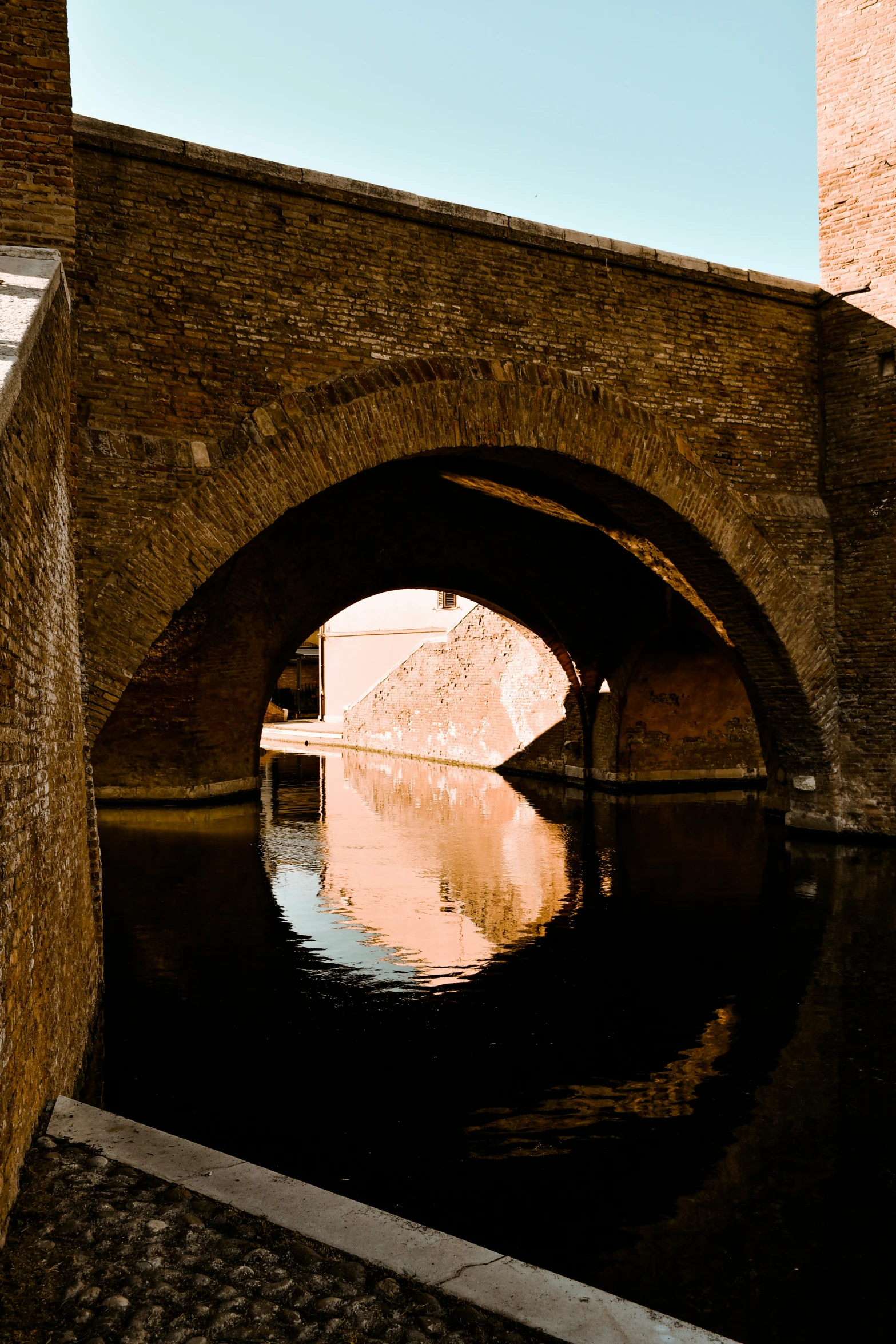 an old brick bridge that is connected to a canal