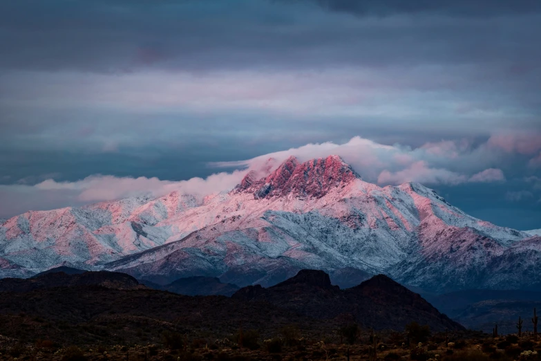 the mountains are surrounded by snow and clouds