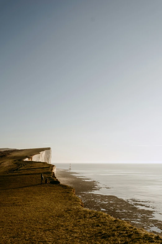 a couple of people sit on the edge of a cliff