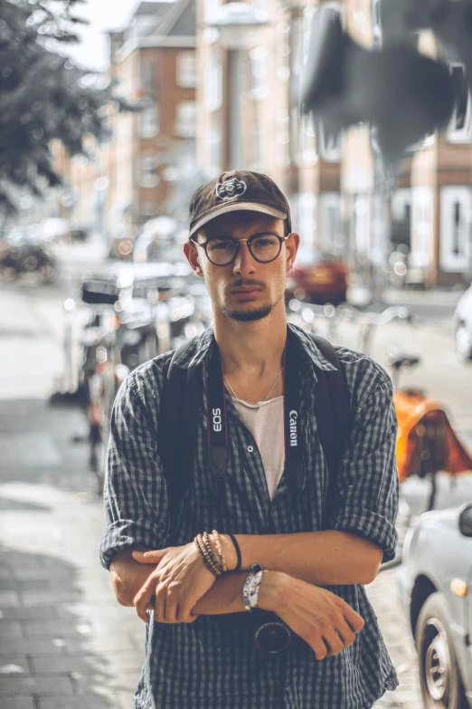 the man wearing glasses and hat looks at the camera