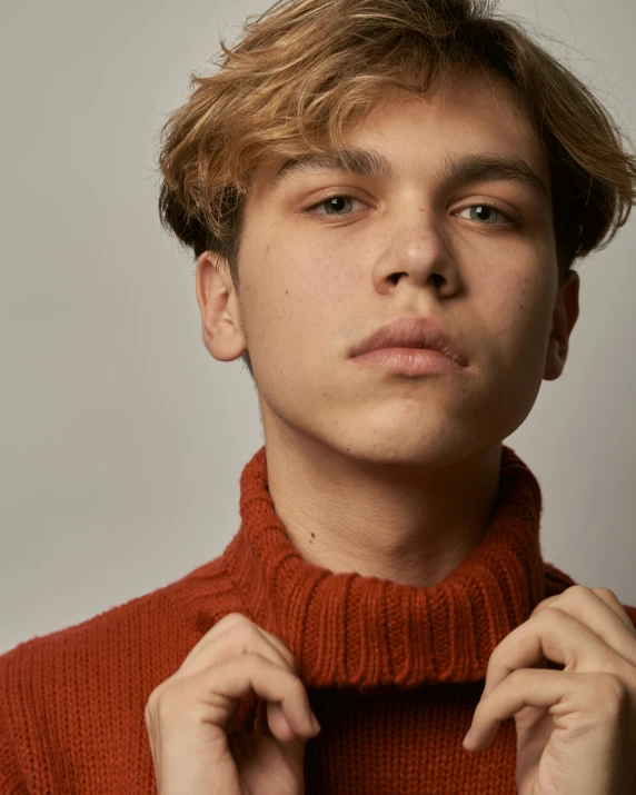 a close up of a young man wearing a turtle neck sweater