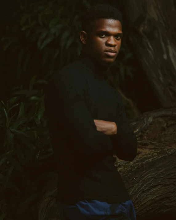 a man poses in front of an array of trees