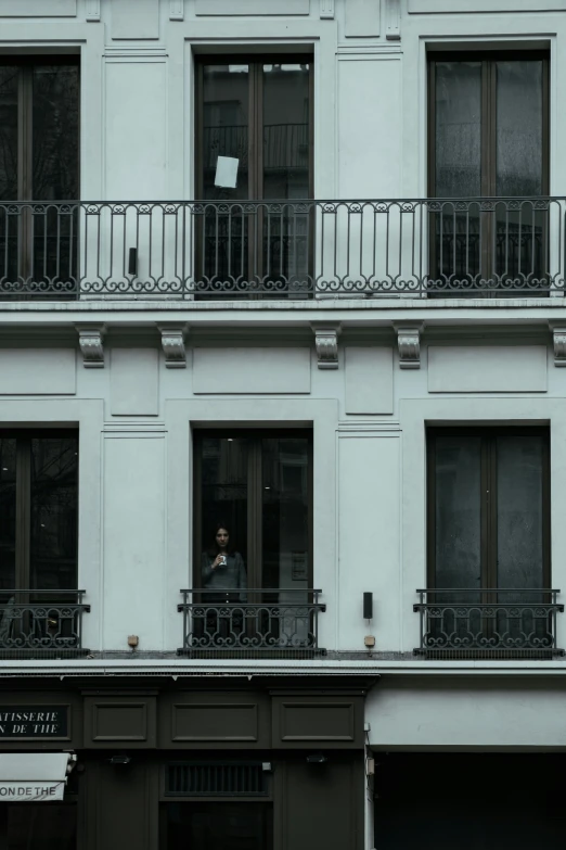 an old building with several balconies has a window that is open to let people out