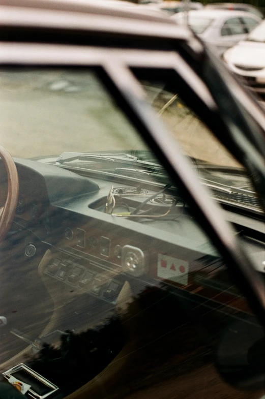 view from inside a car showing the front interior with a wood steering wheel