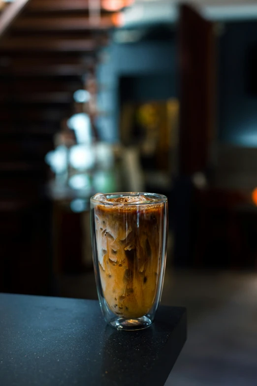 a s glass on a counter, on top of a bar