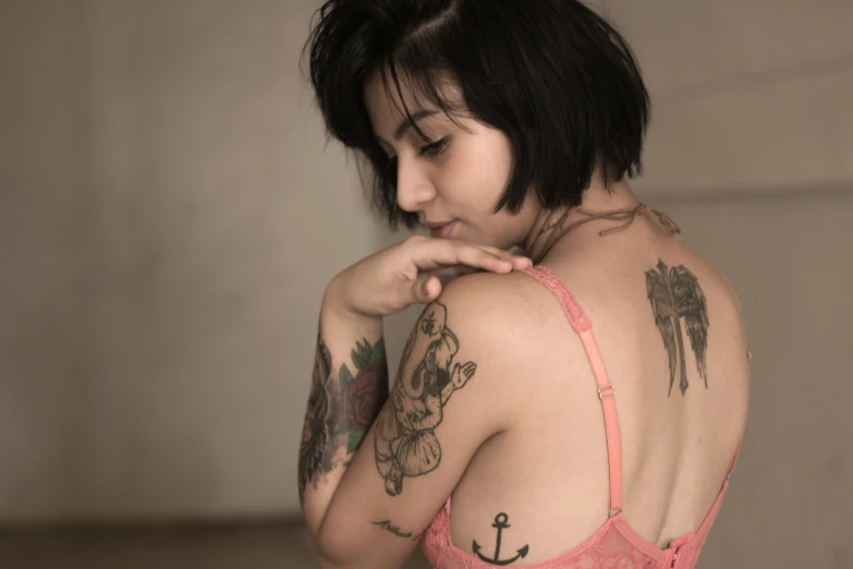 a woman with tattoos on her chest and arm