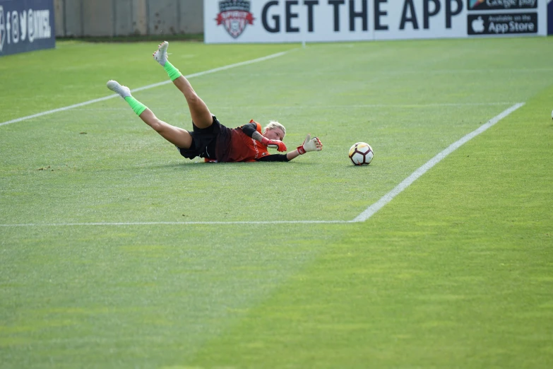 a boy laying on the ground playing with a soccer ball