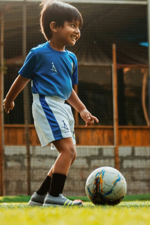 a  standing next to a soccer ball