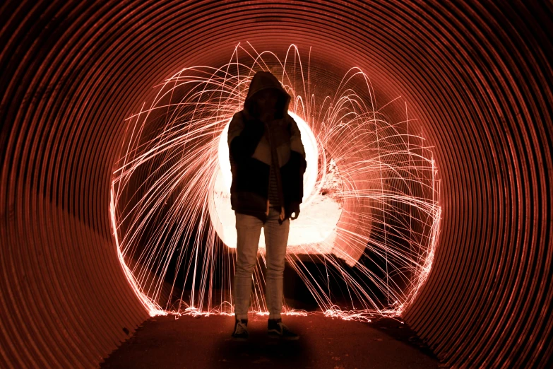 the man is standing in front of a tunnel of fireworks
