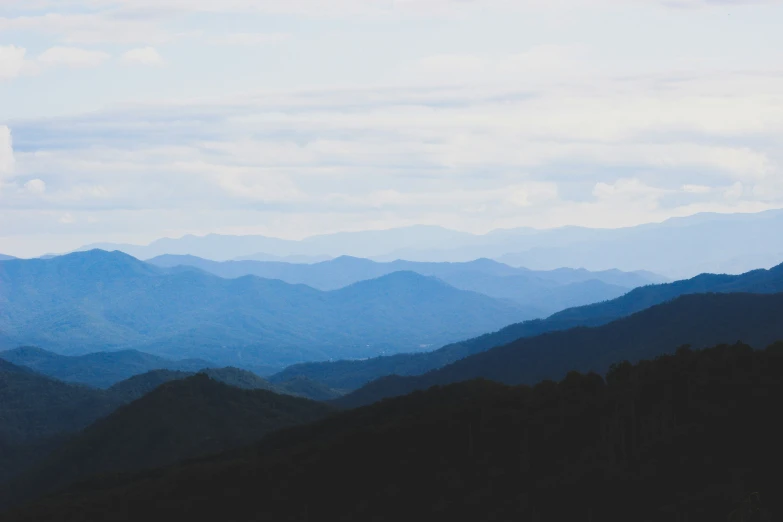 the tops of mountains are shown with dark clouds