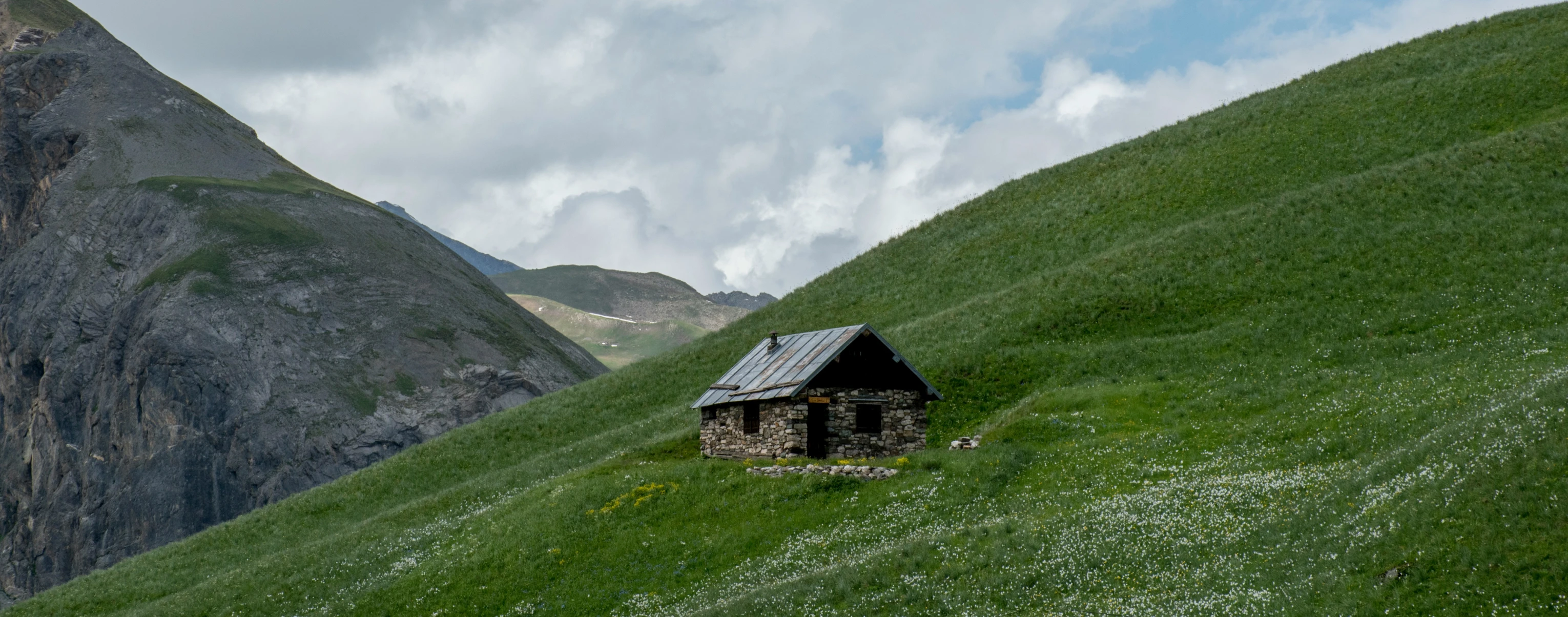 an old cabin nestled in the lush green hills