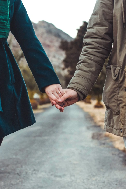 man holding a woman's hand walking down the road