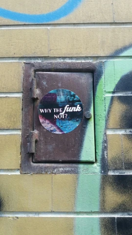 a wall that has a hole and sign that says why the world does not