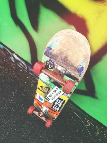 a skateboard leaning against a graffiti covered wall