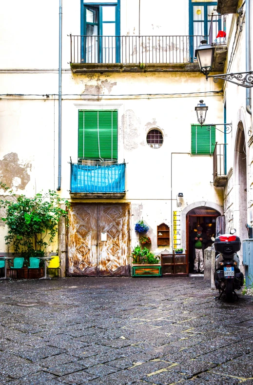 a moped is parked on the side of a cobblestone road