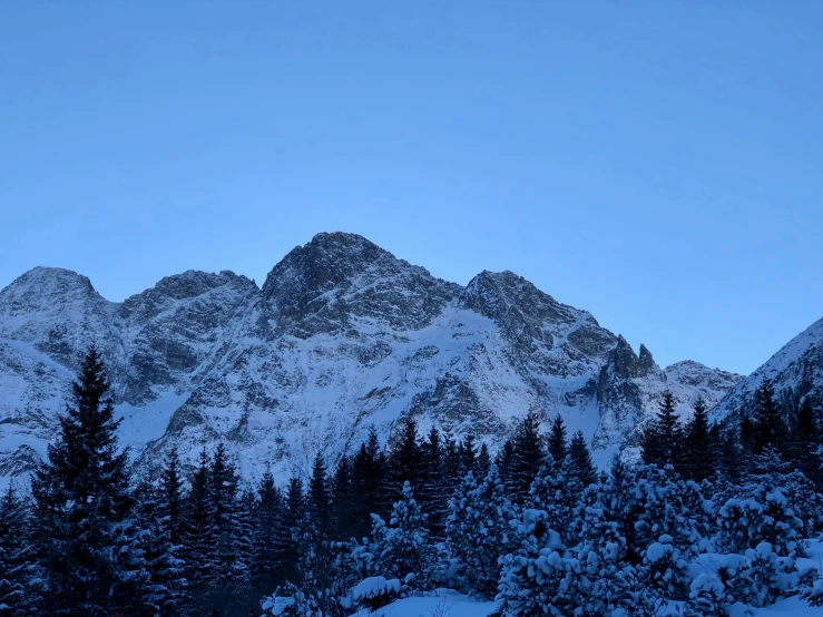 the tops of mountains covered in snow as viewed from a ski slope