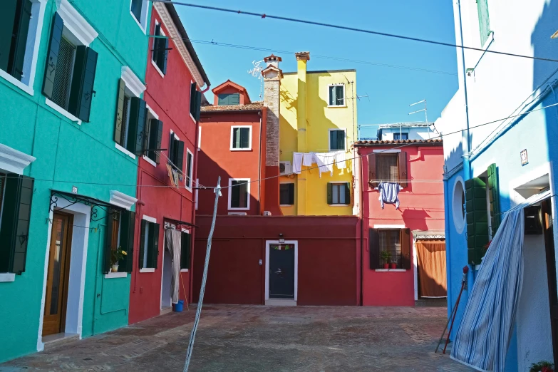 many houses are painted different colors, in a street