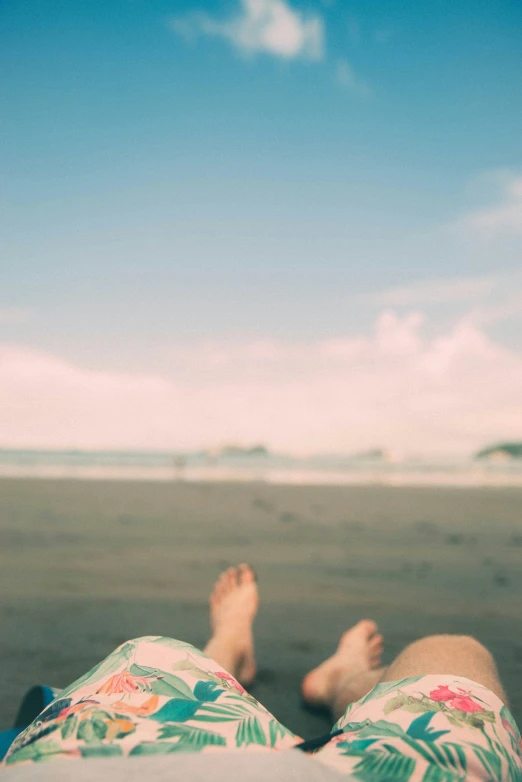 a person with their legs crossed on the beach