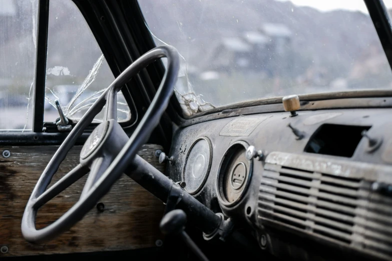 an old and worn up car with a steering wheel