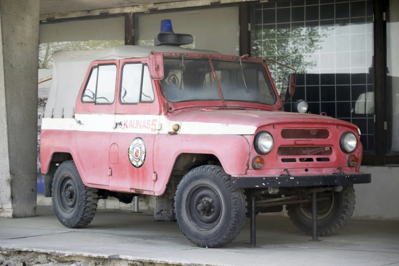 a pink fire truck is parked next to a building