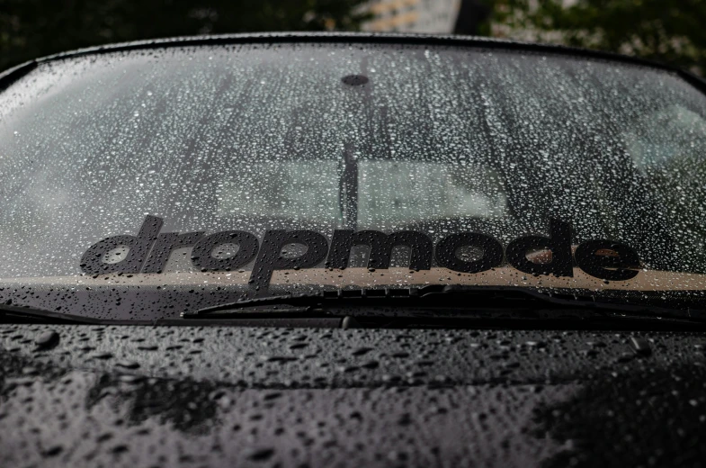 a closeup view of a rain covered windshield with the word dropndole on it