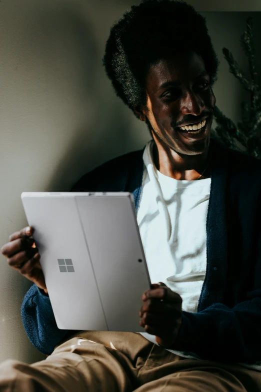 a man holding up an apple laptop