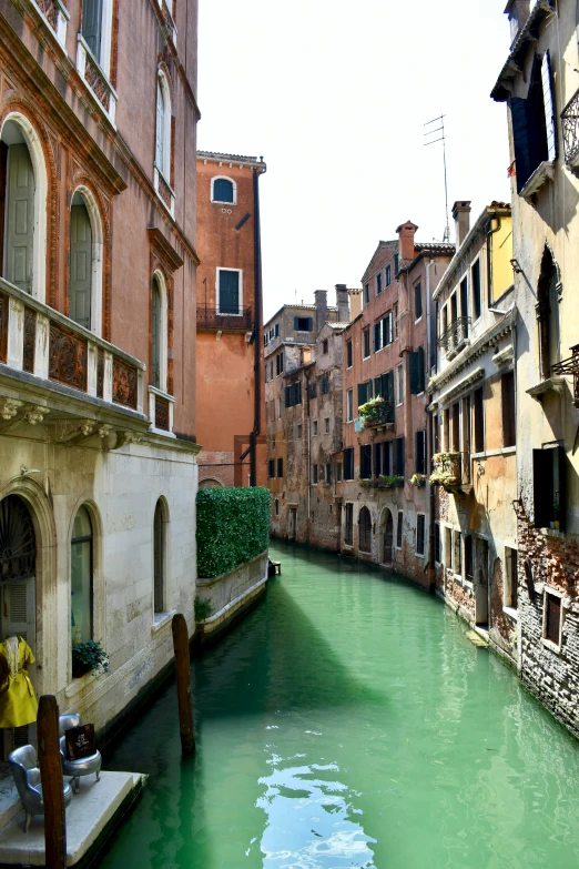 a narrow street with buildings and green water