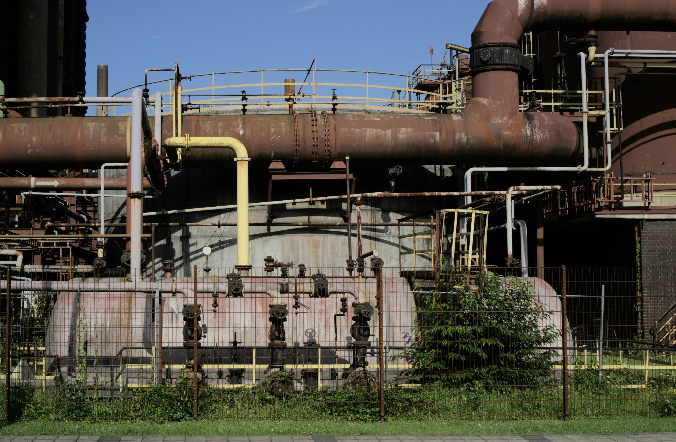 a very large rusted building near the grass