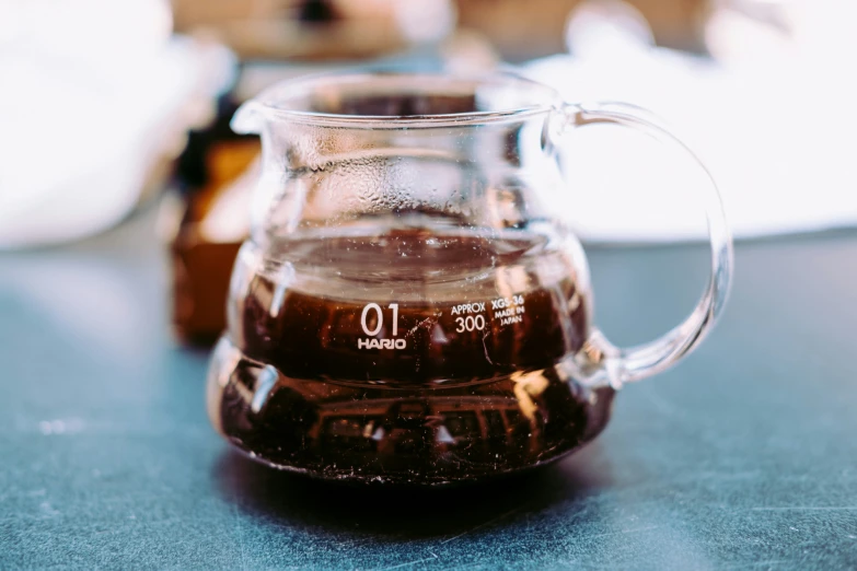 a clear pitcher with liquid in it sitting on top of a table