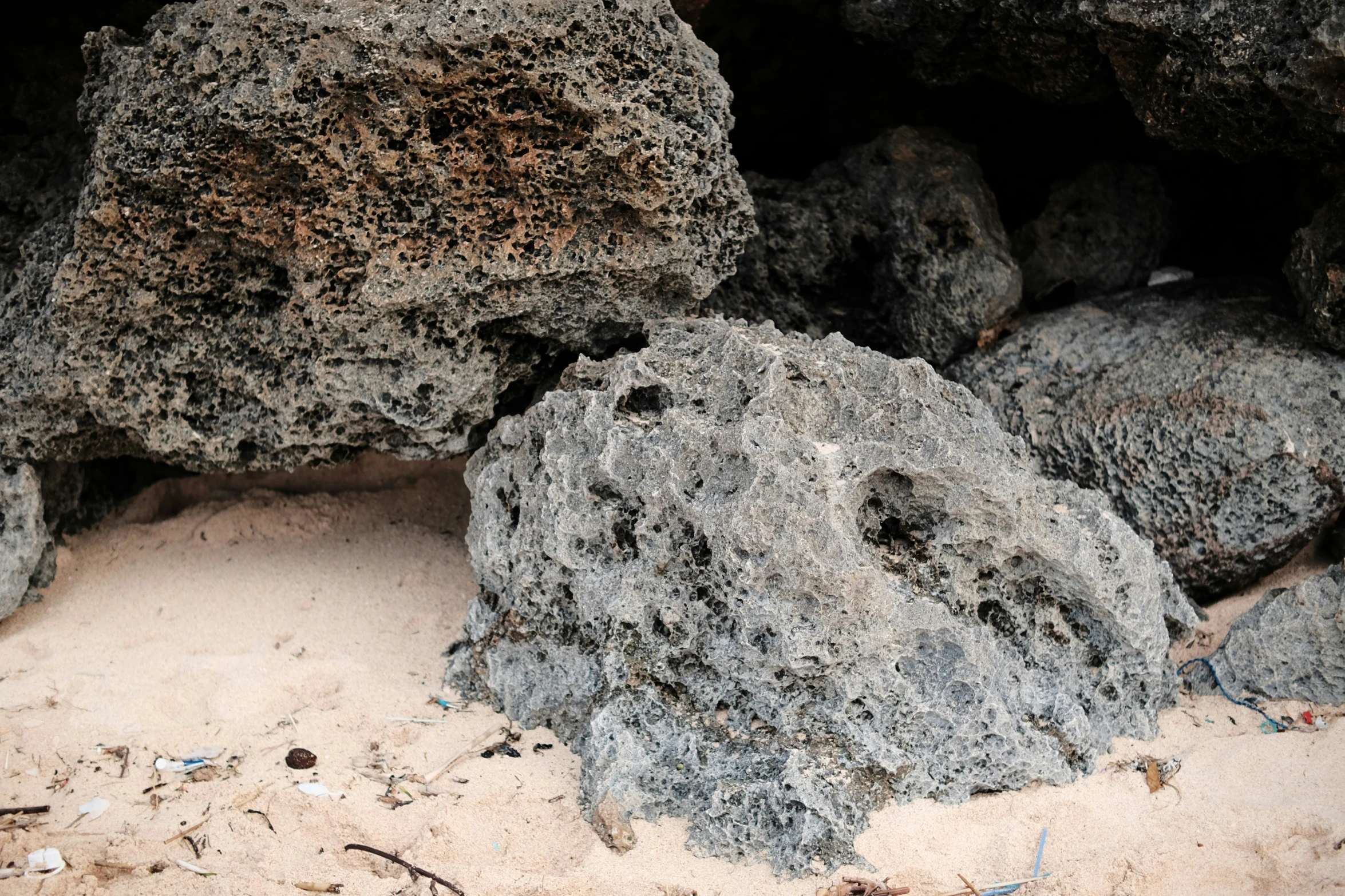 several rocks near each other are covered with sand