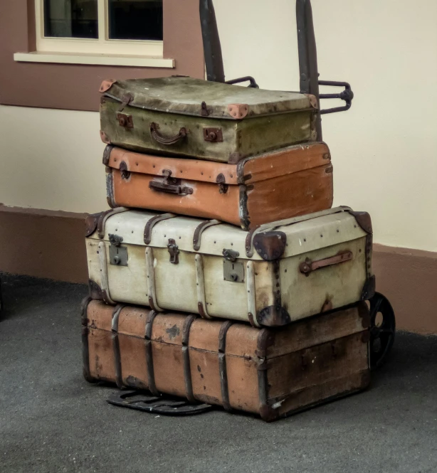 four piece stack of luggage on the ground with one suitcase on top