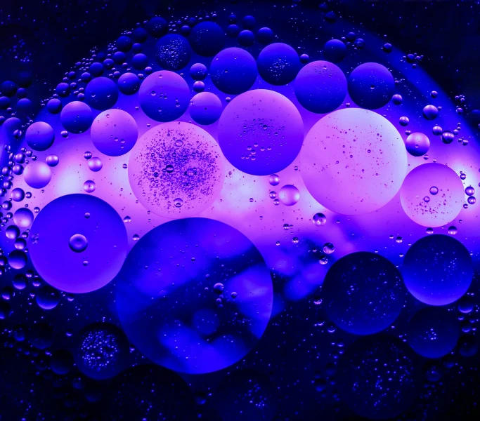 a blue and purple liquid substance sitting on top of a purple surface
