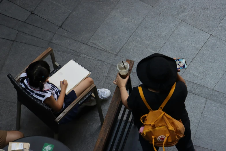 two s siting at a table while one holds a coffee cup