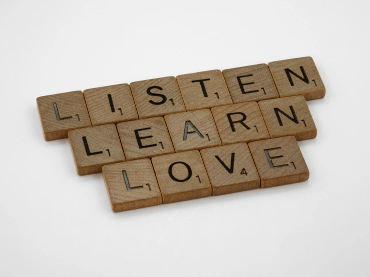 two scrabble tiles that say i listen learn love