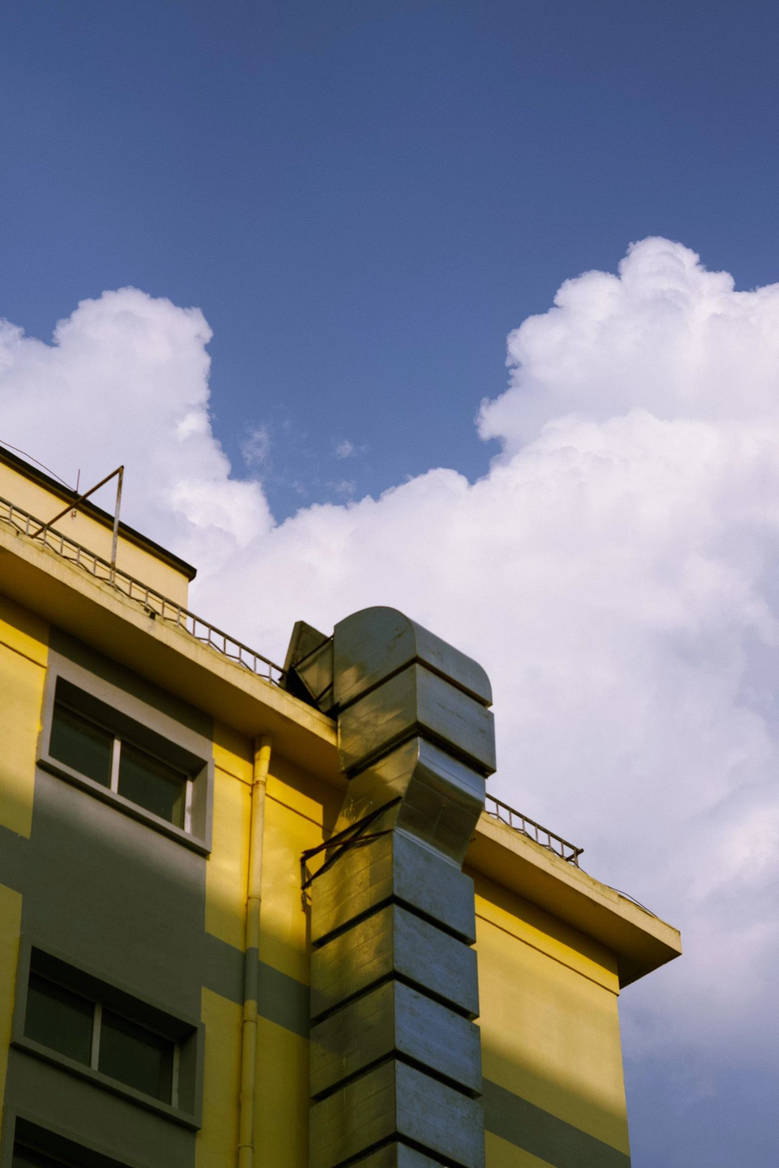 a tall yellow building with a sky background