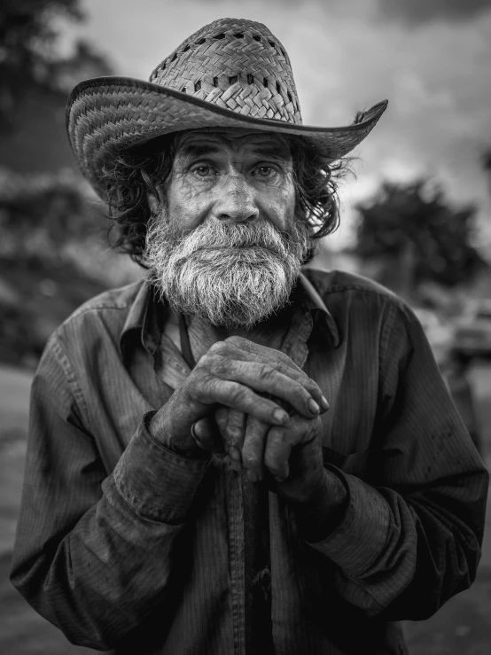 black and white image of an old man with a beard and straw hat