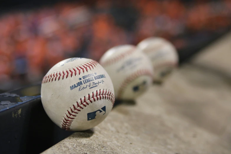 the baseballs are lined up on the dugout wall