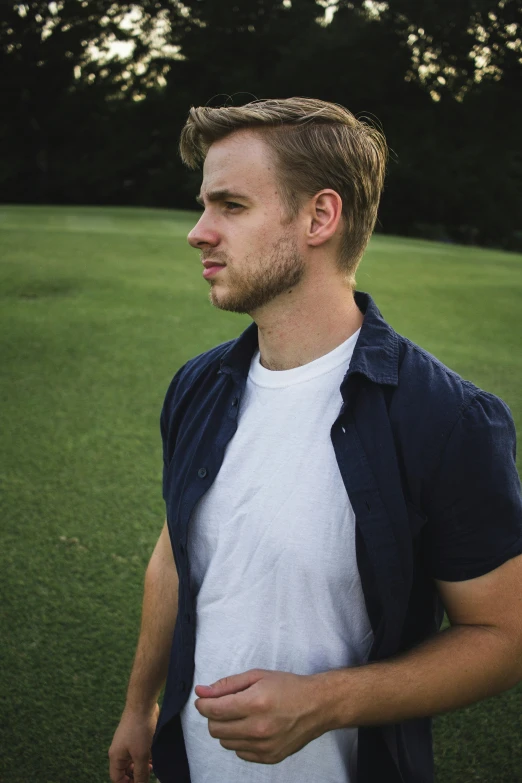 a man standing in the grass on a sunny day